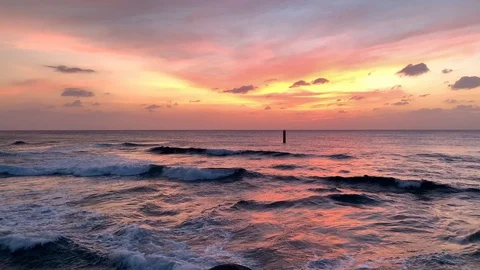Fiery pink sunset with waves breaking over rocks Okinawa Japan Stock Footage 125427638