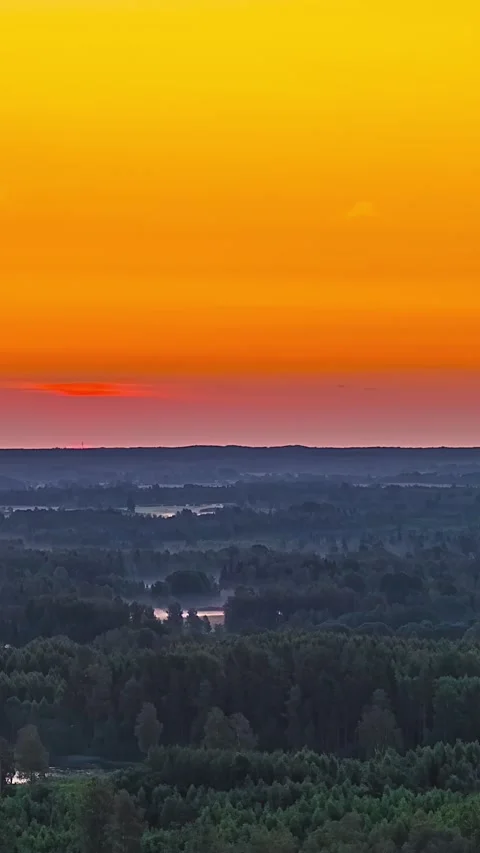 Fiery red sun rising above vast forest Latvian countryside timelapse Stock Footage 340429127