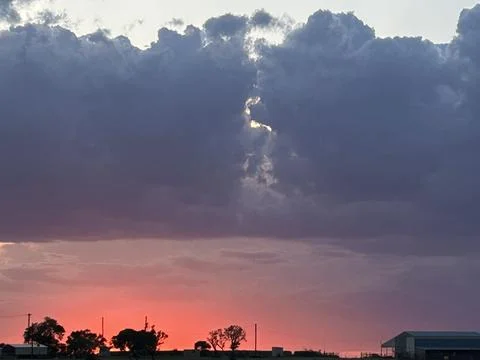 Fiery Red Sunset Beneath Dark Storm Clouds Over Rural Texas Landscape Stock Photos