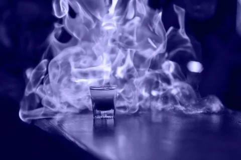 Fiery show at the bar. The bartender makes hot alcoholic cocktail and ignites Stock Photos