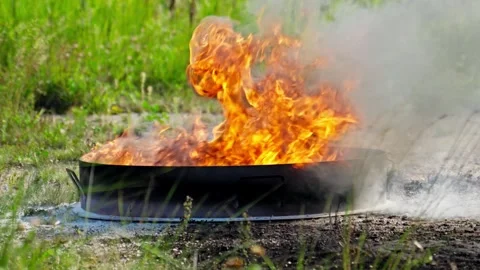 Fiery spectacle in open field as flames engulf manhole cover during sunny day Stock Footage 302110990
