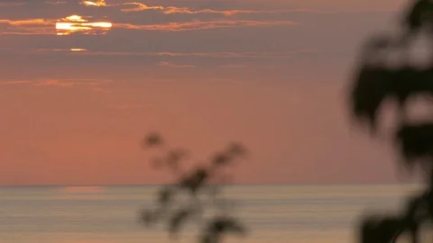Fiery sun setting slowly on the horizon of a water body Stock Footage 77804519