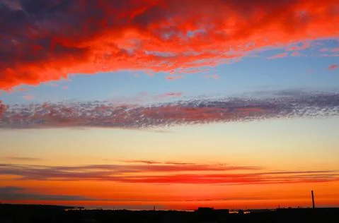 Fiery sunset And red clouds in the blue sky Stock Photos