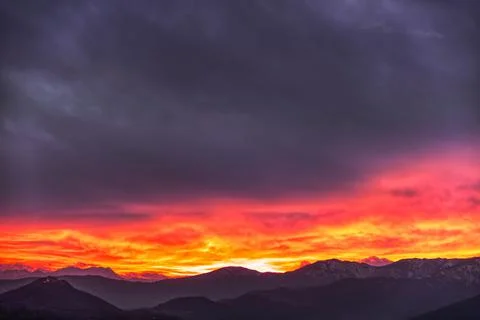 Fiery sunset behind the mountains Stock Photos
