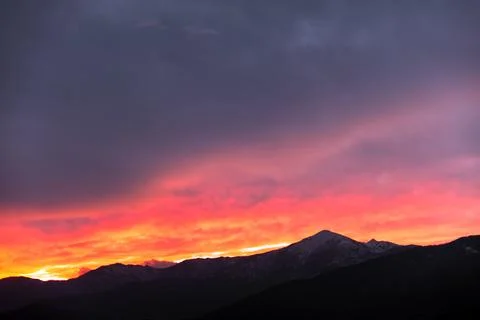 Fiery sunset behind the mountains Stock Photos
