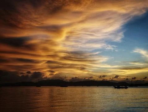 Fiery Sunset Clouds Over Bay with Boats – Dramatic Silhouette Foto stock