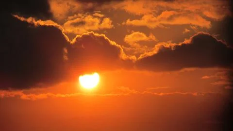 Fiery sunset with dramatic clouds, capturing solitude and nature's beauty Stock Photos