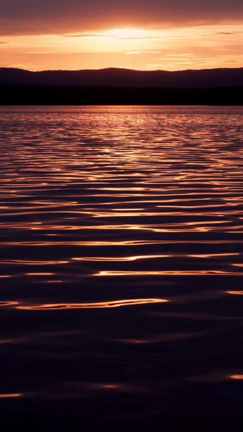 A fiery sunset on the lake with a mirror reflection of light on the water. Stock Footage 276877074