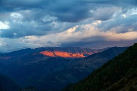 Fiery sunset light on the Caucasus mountains Stock Photos