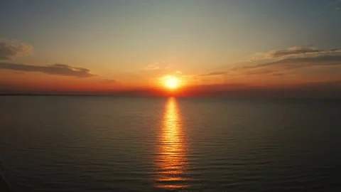 Fiery Sunset Over Ocean Horizon with Reflective Sun Path and Beach Shoreline Stock Footage 319804527