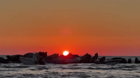 Fiery sunset over sea rocks with orange glowing sky horizon Stock Footage 311842235