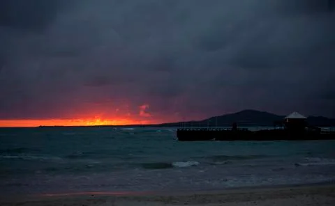 Fiery sunset with pier Stock Photos