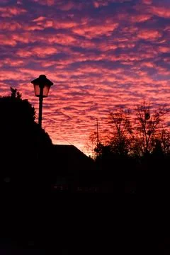 Fiery Sunset with Silhouetted Lamppost Stock Photos