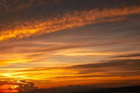 Fiery Sunset Sky with Wispy Clouds Over Mountains Stock-Fotos