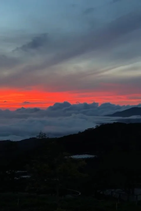 Fiery Sunset Spreading Glow Over Floating Clouds Stock Footage 321180912