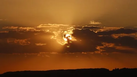 Fiery Sunset: Sun Partially Obscured by Dramatic Clouds Stock Footage 302312768