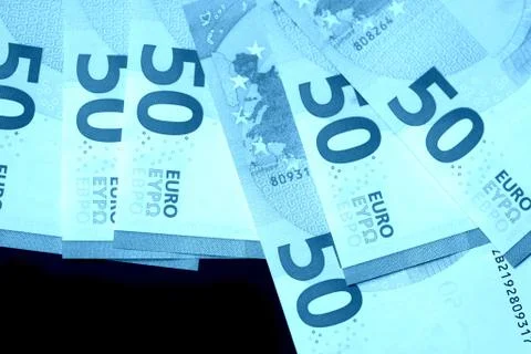 Fifty euro notes on a dark background close up. Blue color toned Stock Photos