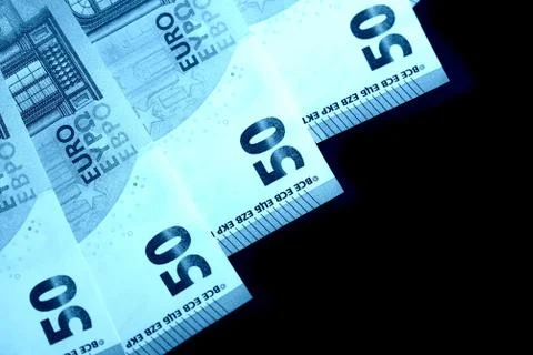 Fifty euro notes on a dark background close up. Blue color toned Stock Photos