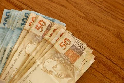Fifty real bills in focus on table with hundred real bills in background Stock Photos