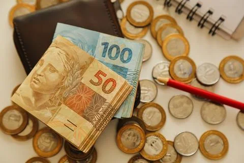 Fifty real notes and other notes and coins on the table with wallet, pencil.. Stock Photos