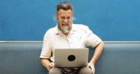 Fifty-year-old man with gray hair making a video call on the street Stock Footage 164865260