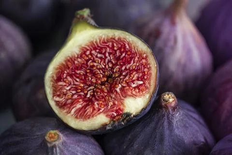 Fig cut in half lying on a ripe fig. Stock Photos