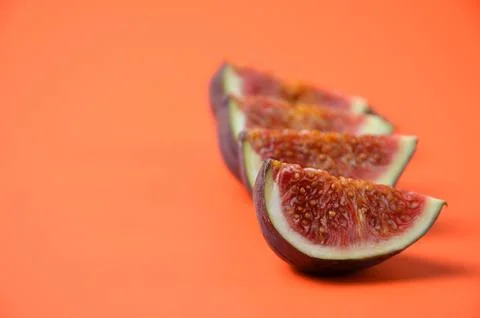 Fig slices on an orange background. Stock Photos
