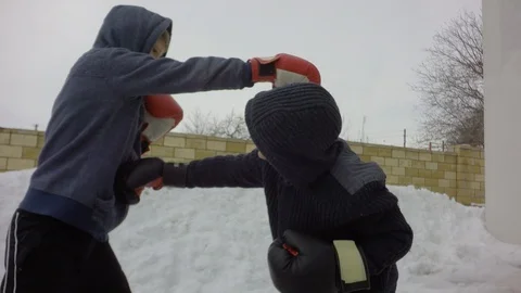 A fight with a shadow. A large snowdrift. Two boys are training. Video stock 87739453