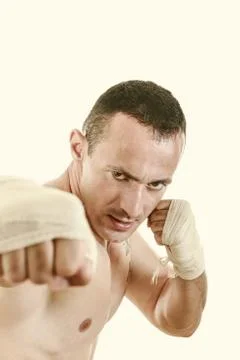 Fighter with bandage on hands in fighter position and punch with fist Stock Photos