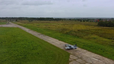 Fighter combat aircraft move along the runway at old empty airfield. Top view. Stock Footage 118676136