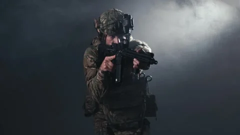 Fighter in contemporary combat equipment aims weapon forward, showcasing Stock Footage 336490708