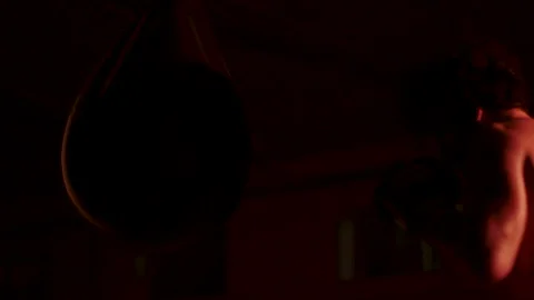 A fighter hits a punching bag with gloves during his training Stock Footage 141964237