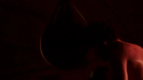 A fighter hits a punching bag with gloves during his training Stock Footage 141964432