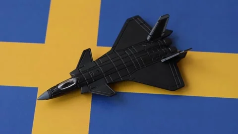 A fighter jet against the Swedish flag as a conceptual background representing d Stock Footage 339440406