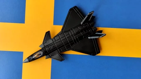 A fighter jet against the Swedish flag as a conceptual background representing d Stock Footage 339440460