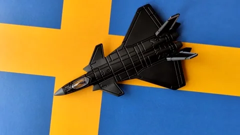 A fighter jet against the Swedish flag as a conceptual background representing d Stock Footage 339440472