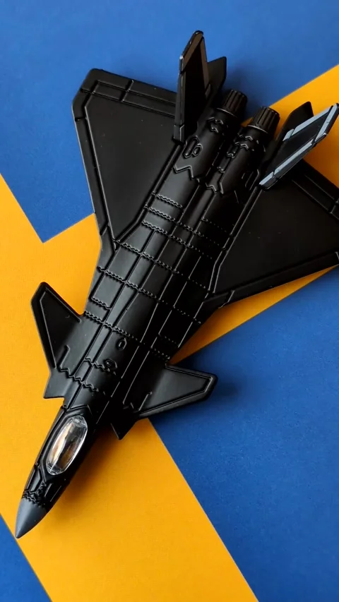 A fighter jet against the Swedish flag as a conceptual background representing d Stock Footage 339440487
