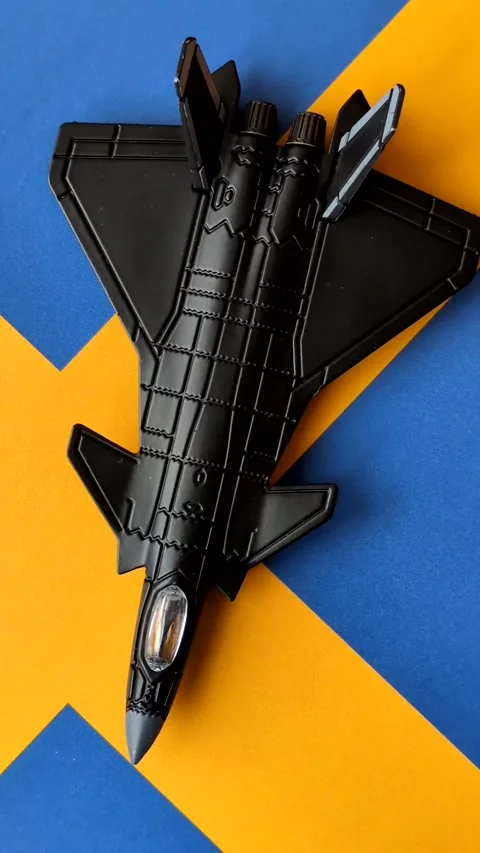 A fighter jet against the Swedish flag as a conceptual background representing d Stock Footage 339440495
