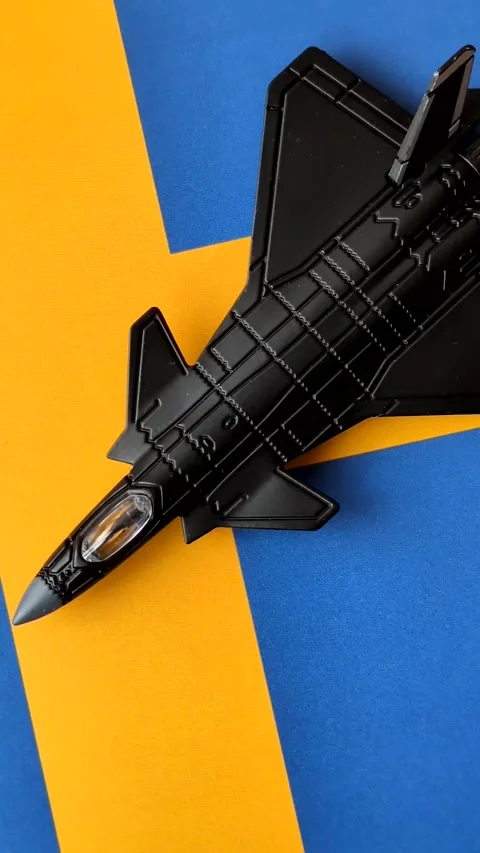 A fighter jet against the Swedish flag as a conceptual background representing d Stock Footage 339440506