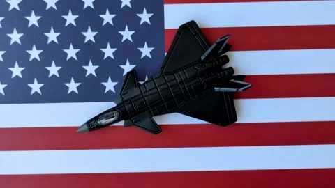 A fighter jet against the US flag as a conceptual background representing defens Stock Footage 337825469