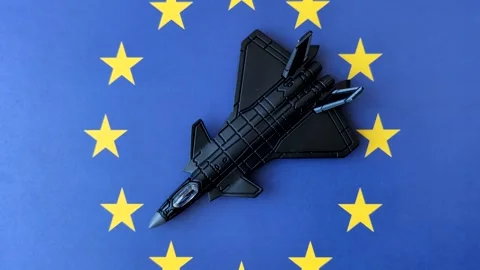 A fighter jet on the European Union flag as a conceptual backdrop representing E Stock Footage 337825339
