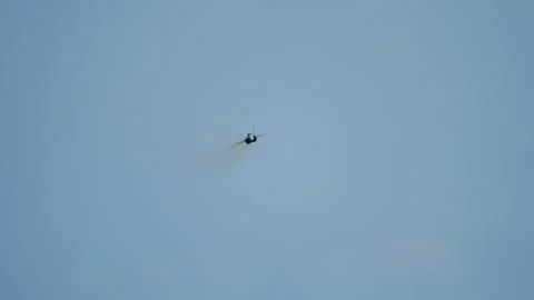 Fighter jet with exhaust trail flying in hazy pale sky Stock Footage 336740402