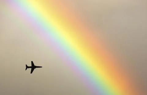 A fighter jet flies through a rainbow over the Ambleside, Lake District, UK. Stock Photos