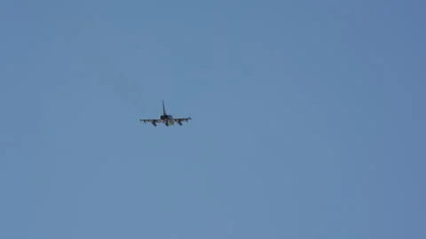 Fighter jet flying in clear blue sky Stock Footage 334409931
