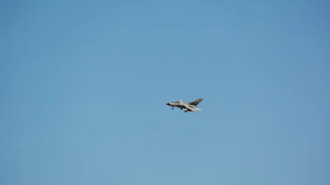 Fighter jet flying in a clear blue sky with landing gear deployed Stock-Footage 341778431