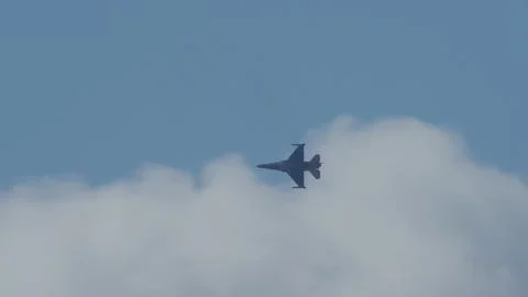 Fighter jet soaring above clouds during flight display Stock Photos