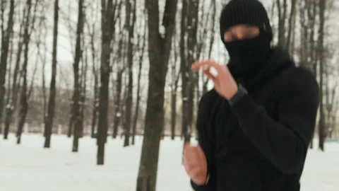 A fighter of martial arts, in black clothes with a mask on his face, performing Stock Footage 111993542