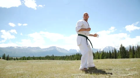 Fighter performing karate stance against rock crashing down from cliff Stock Footage 65484654
