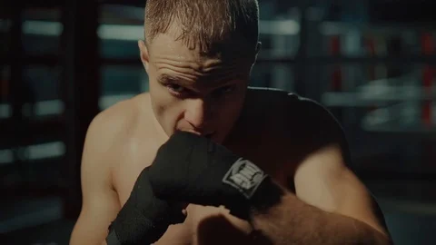 Fighter is performing strikes by hands, looking at camera, close-up view Video stock 98744251