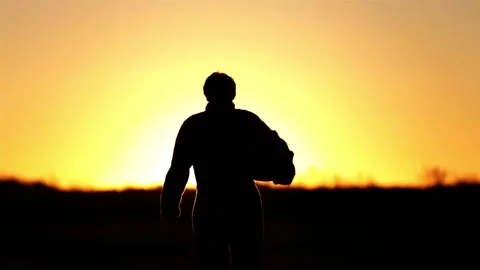 Fighter Pilot Walking on Airfield at Sunset, Silhouette Shot - Slow Motion Stock Footage 236478650
